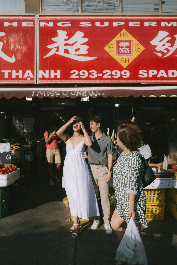 Candid portrait picking fruit at a market stall, Chinatown, Toronto