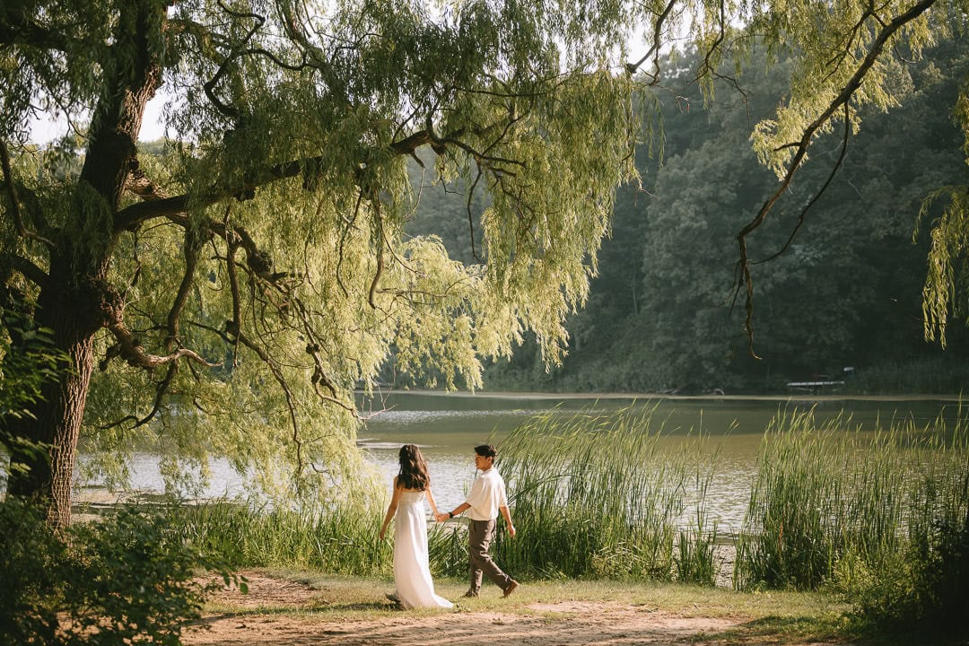 Cinematic engagement portrait framed by willow trees by the lake, High Park, Toronto