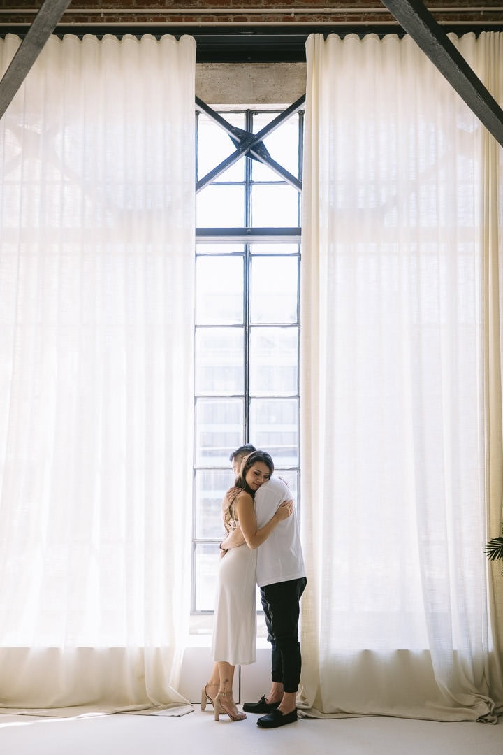 Engagement portrait by the metal window in the solarium, Preto Loft, Toronto