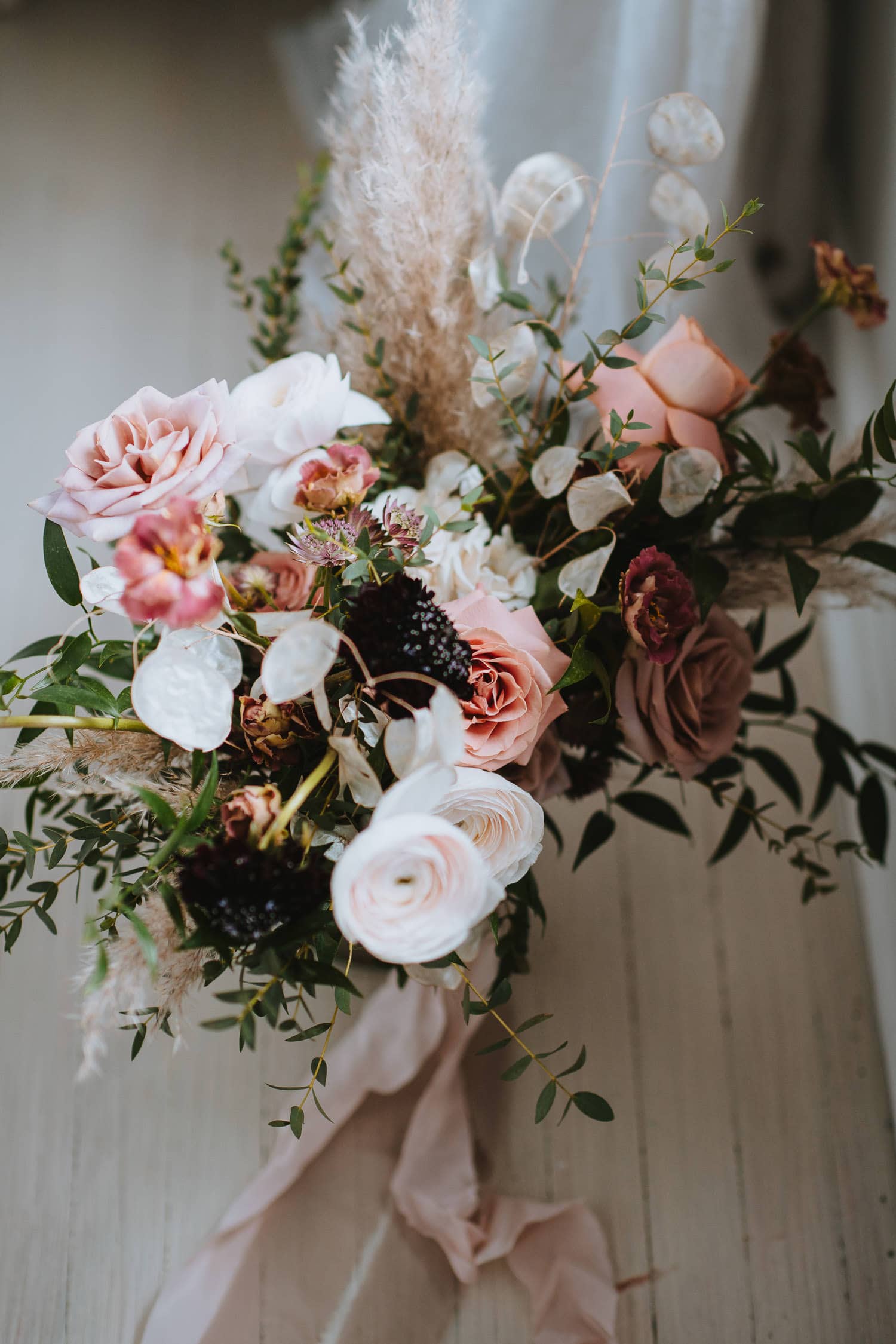 bridal bouquet with dusty pinks, whites, and pops of burgundy